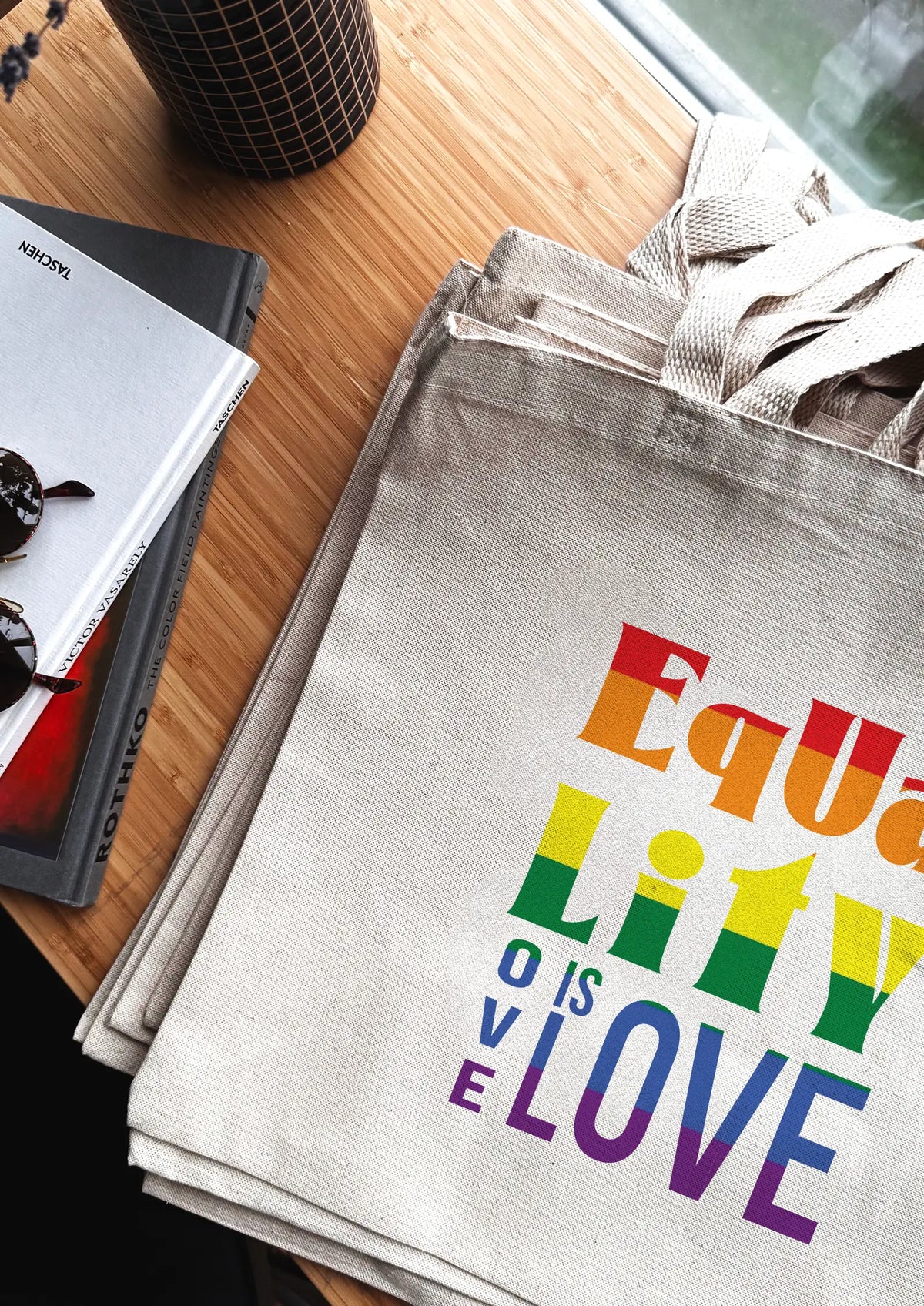 Tote bag with 'Equality is Love' message on a wooden surface