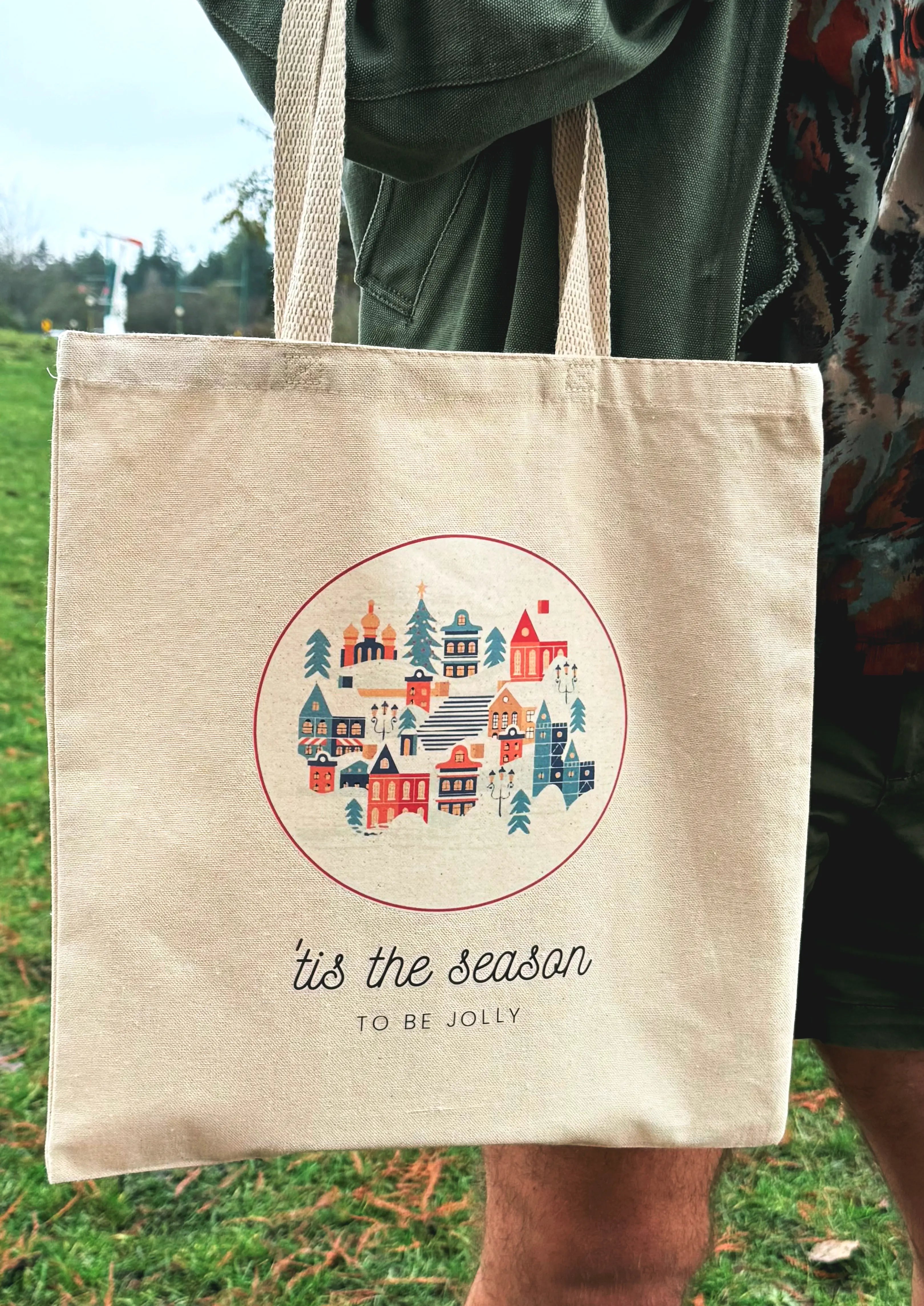 Holiday Village canvas tote bag resting on a couch in a cozy living room setting