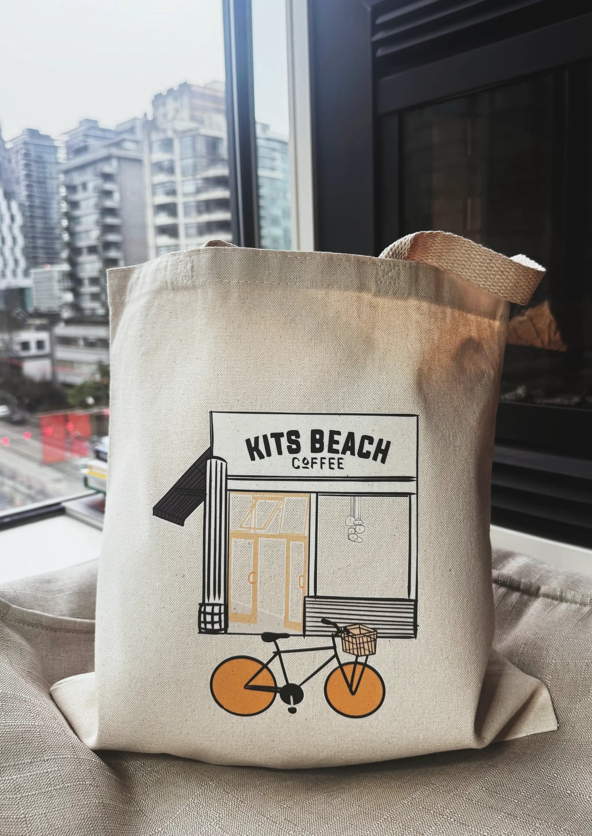 Tote bag with 'Kits Beach Coffee' design on a couch