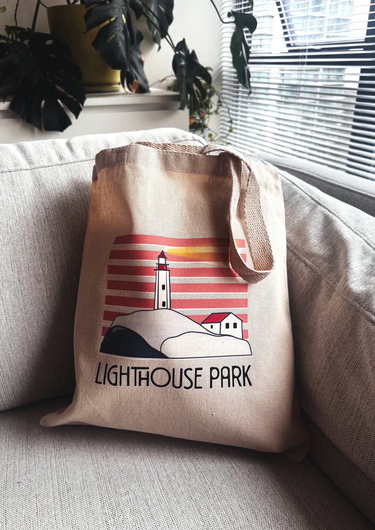 Tote bag with 'Lighthouse Park' design on a couch