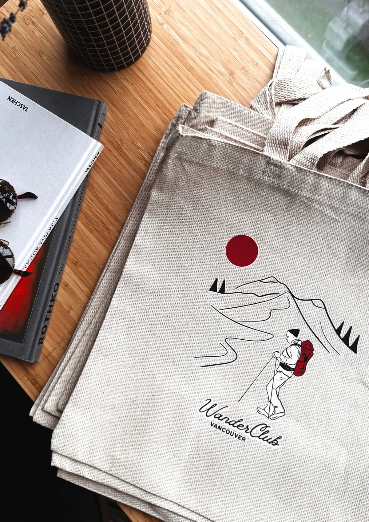 Gray tote bag with mountain and sun design on a wooden surface